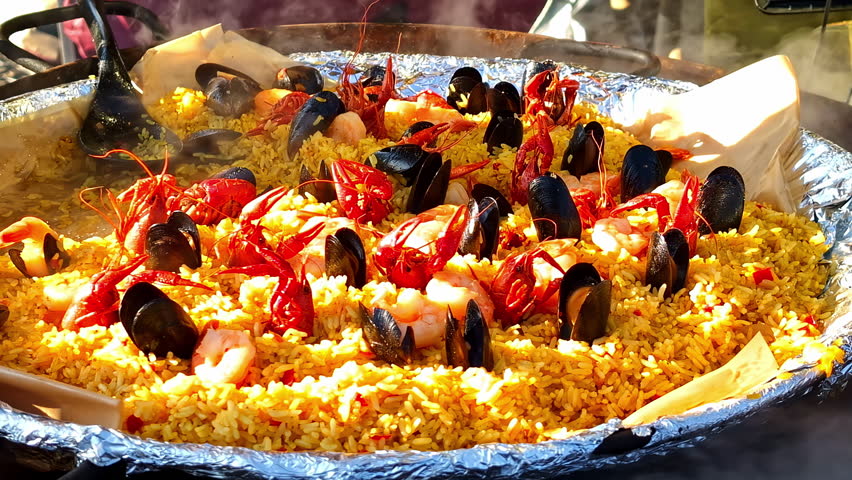 Delicious seafood paella with shrimp, crawfish, and mussels over vibrant yellow rice