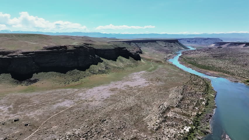 Drone view of Snake River Canyon in Idaho, a winding river, and stunning desert landscapes. Wide view