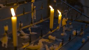 Burning candles slowly melt on a metallic support, creating a warm glow. The flickering flames illuminate the surroundings, evoking a serene and peaceful atmosphere - Powered by Shutterstock - Get 15% off with code: PIKWIZARD15