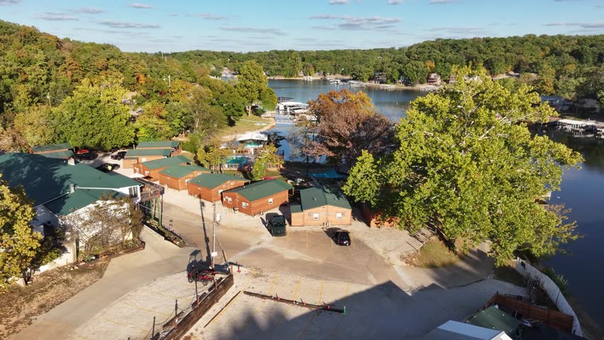 Aerial view, flying over the river, forest, small houses on the water and hotels. Missouri, Ozark In summer, green trees, landscape. Drone 4K