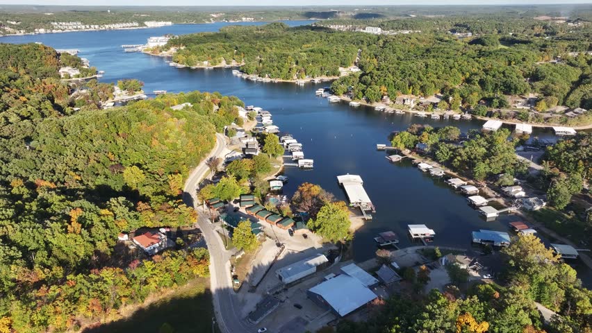 Aerial view, flying over the river, forest, small houses on the water and hotels. Missouri, Ozark In summer, green trees, landscape. Drone 4K
