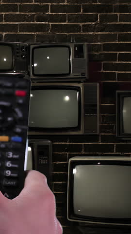 Wall of Retro TVs Against Brick Wall Turning On With Green Screens and Color Noise - Vertical 4K