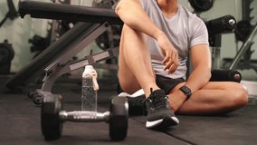 Healthy Asian man athlete do sport workout exercise weight training at fitness gym. Sportsman cooling down drinking water from a bottle after exercising. People wellness healthcare motivation concept. - Powered by Shutterstock - Get 15% off with code: PIKWIZARD15