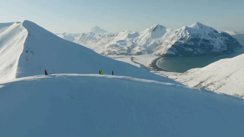 Group of mountain tourists climb snowy mountains in winter, aerial view