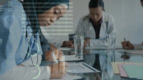 Medical professionals working at desk with data processing animation overlay. Healthcare, technology, innovation, data analysis, teamwork, collaboration - Powered by Shutterstock - Get 15% off with code: PIKWIZARD15