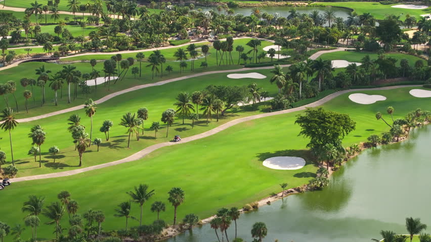 An aerial view showcases Floridas vibrant golf courses, serene lakes, sand traps, swaying palm trees, and a bright blue sky, creating a perfect landscape for relaxation and recreation
