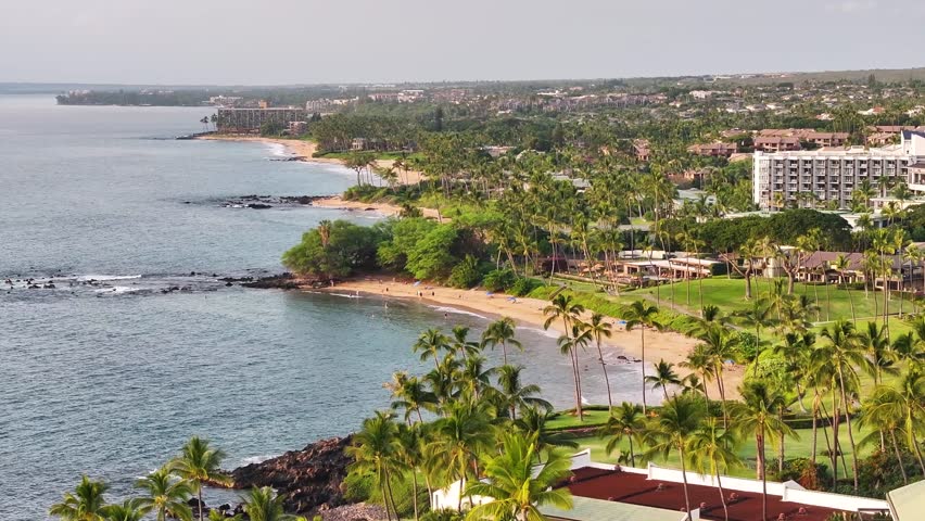 Aerial view of Wailea-Makena Maui, Hawaii oceanfront 5-star resort hotels capturing tropical landscape, deep blue seascape and upscale villa vacation homes along ocean beach - 4K Drone