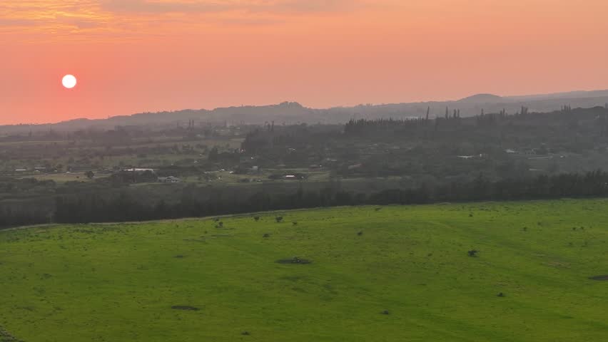 Aerial view of beautiful morning sunrise over countryside farm and surrounding Maui, Hawaii landscape on north east side of island - 4K Drone