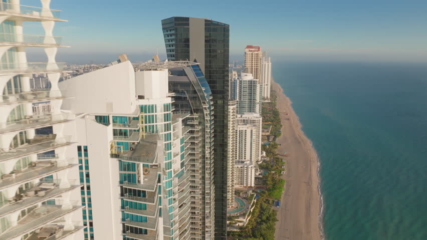 Experience the stunning aerial view of Sunny Isles Beach, North Beach, and Newport Fishing Pier at sunrise in Florida, captured in vibrant 4K resolution for a mesmerizing sight