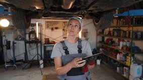 Skilled female mechanic using digital tablet, inspecting car on a lift in a garage, slow motion - Powered by Shutterstock - Get 15% off with code: PIKWIZARD15