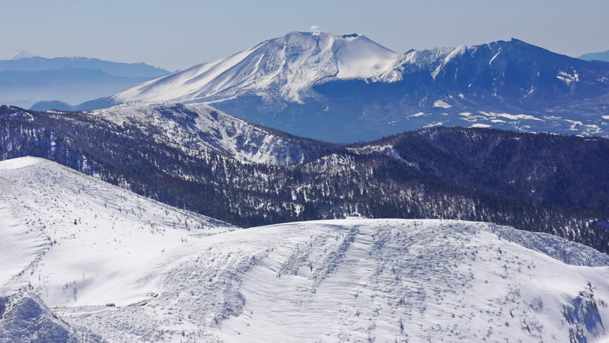 Snow covered steaming volcano Mount Asama in Nagano, Japan. Handheld shot