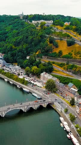Vertical video. Namur, Belgium. Citadelle de Namur - 10th-century fortress with a park, rebuilt several times. Panorama of the central part of the city. River Meuse. Summer day, Aerial View. Rich col