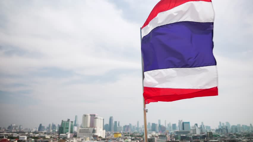 Close up of Thailand flag waving in wind in front of modern city