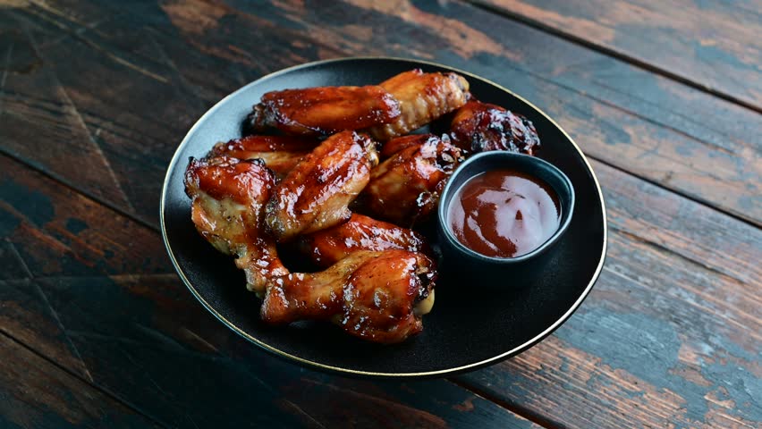 Mouthwatering BBQ chicken wings, coated in a rich sauce, perfect for finger-licking appetizers at any gathering.