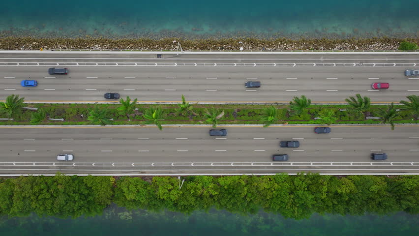 A stunning aerial view showcases the road in the Port of Miami, surrounded by lush greenery and vibrant waters, encapsulating the beauty of Florida