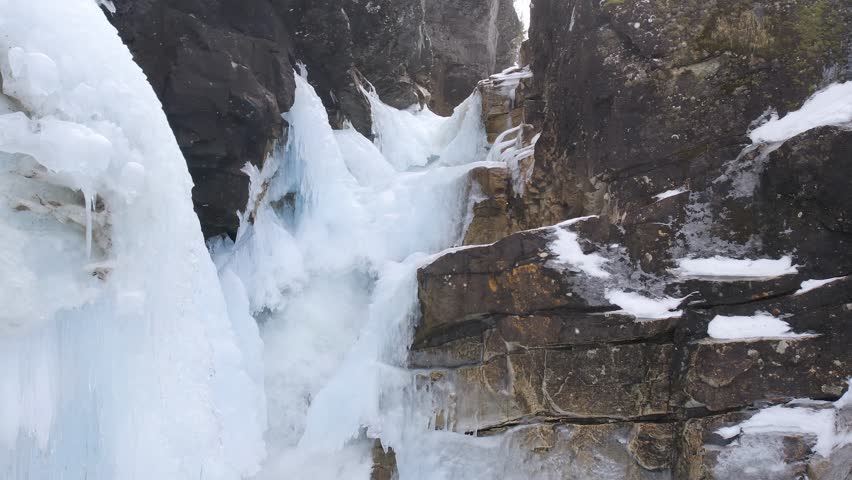 Frozen Mongefossen Waterfall Cascading into Icy Rauma River, Norway