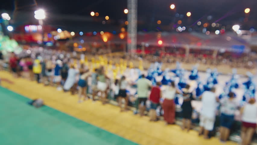 Brazilian carnival. Naturally blurred footage of the brazilian carnival and parade of school of samba performing on a sambodrome. People dance and celebrate on night parade of school of samba