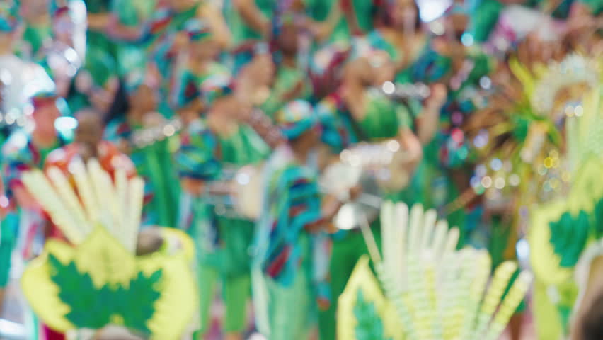 Brazilian carnival. Naturally blurred footage of the brazilian carnival and parade of school of samba performing on a sambodrome. People dance and celebrate on night parade of school of samba