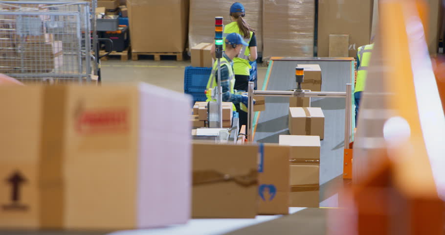 Personnel Carefully Loading Various Boxes on Conveyor Lines in a Mail and Parcel Processing Center. Employees in Logistics Terminal Facilitating the Movement of Cargo For International Shipping