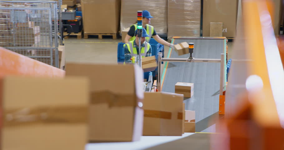 Personnel Carefully Loading Various Boxes on Conveyor Lines in a Mail and Parcel Processing Center. Employees in Logistics Terminal Facilitating the Movement of Cargo For International Shipping