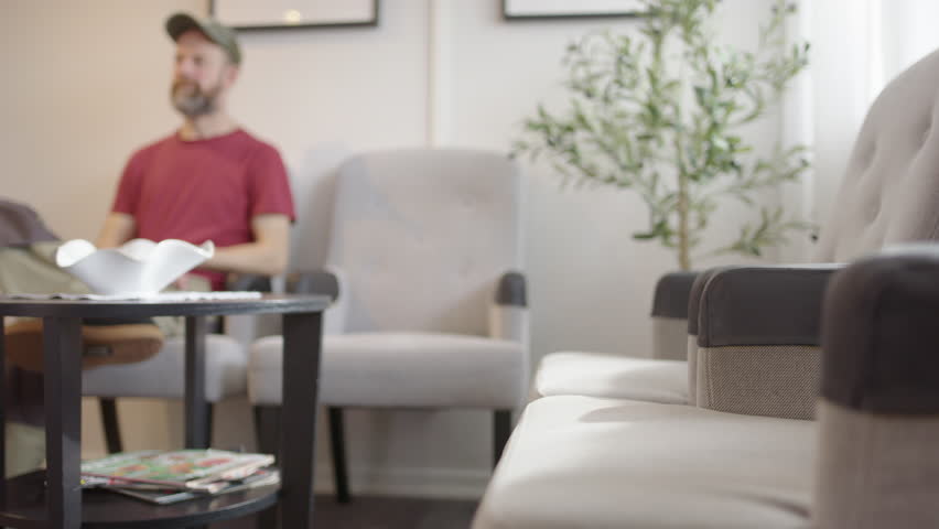 Man in his 40s waits in a waiting room, slider. Can be used for many subjects