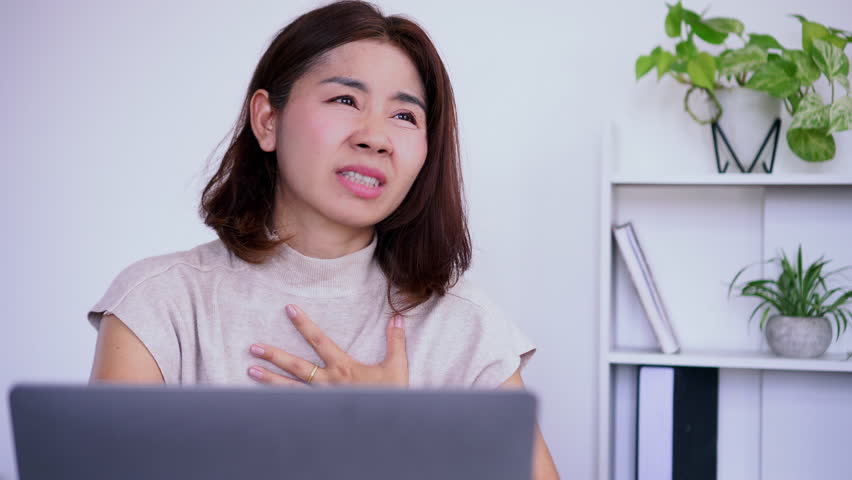 asian woman panic attack, feeling short of breath, scared, and overwhelmed, breathing quickly with a sense of fear and anxiety, about to cry due to intense worry and stress