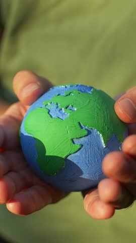 colorful model of planet earth in hands vertical video. environment, nature, ecology