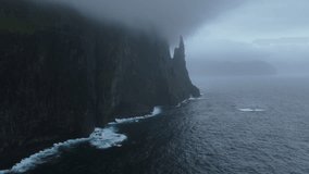 Discovering the cliffs from above and where Trollkonufingur (Trøllkonufingur) is located on a cloudy day. The Troll Woman's Finger, Vagar, Faroe Islands. - Powered by Shutterstock - Get 15% off with code: PIKWIZARD15