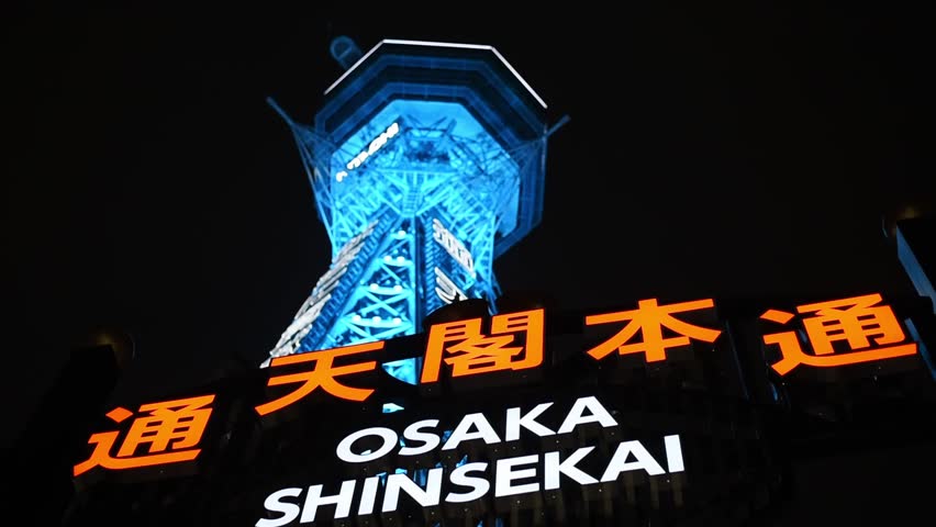 Shinsekai neon sign against the iconic Tsutenkaku tower illuminated in neon blue at night. Shinsekai, Osaka, Kansai, Japan