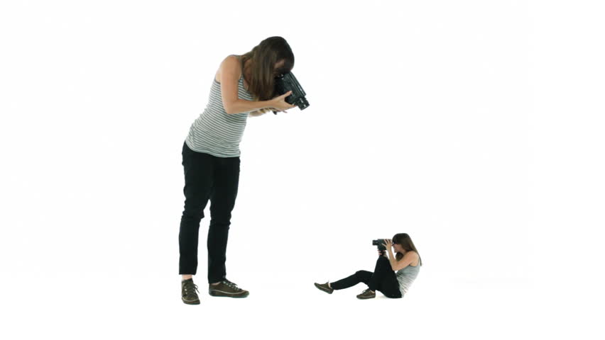 Woman films a smaller version of herself, who in turn lays back to film her