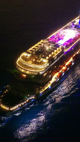 Cruise ship illuminated at night. Vertical video