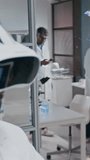 Vertical side dolly out shot of female dark-skinned medical scientist wearing virtual reality headset and working on digital tablet, using high tech technology in developing cure for serious diseases - Powered by Shutterstock - Get 15% off with code: PIKWIZARD15