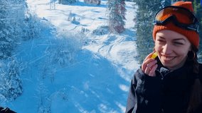 Slow-motion shot of a woman applying lip balm and laughing as she sits in a gondola lift, preparing to hit the powdery slopes of the snow-covered alpine mountains in Lenk, Switzerland - Powered by Shutterstock - Get 15% off with code: PIKWIZARD15