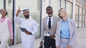 Group of multiethnic business people meeting an emirati businessman - International corporate business team bonding outdoors in the city	 - Powered by Shutterstock - Get 15% off with code: PIKWIZARD15
