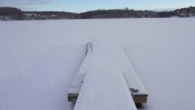 Deep cold winter in Sweden. Northern landscape frozen lake snow covered and wooden pier stuck or locked in ice - Powered by Shutterstock - Get 15% off with code: PIKWIZARD15