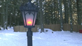 Warm Candle-Like Bulb Glowing on Wooden Fence in Snowy Forest, Winter Night Ambience - Powered by Shutterstock - Get 15% off with code: PIKWIZARD15