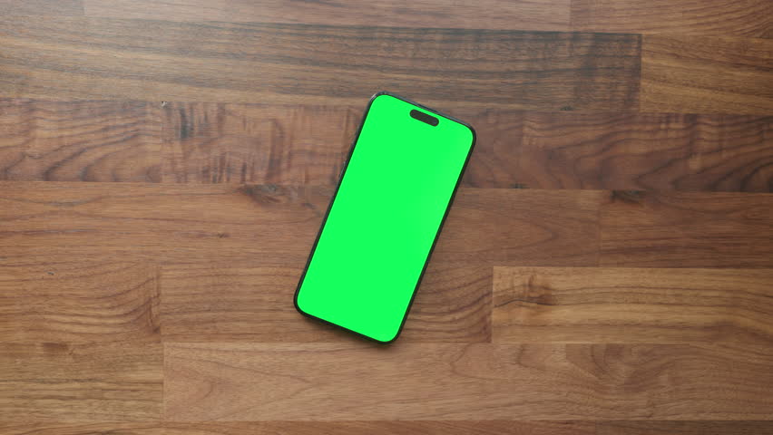 Smartphone with Green Screen on Wooden Desk, Office Workspace Setup for Mockup, VFX, App Design, or Presentation Use Slanted, Phone Only Zoom Out Ease Out
