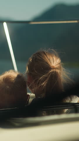 Lovely kids lean out of sailboat hatch having trip across ocean on nice day. Happy boy and girl ride yacht on summer vacation. Amazing journey