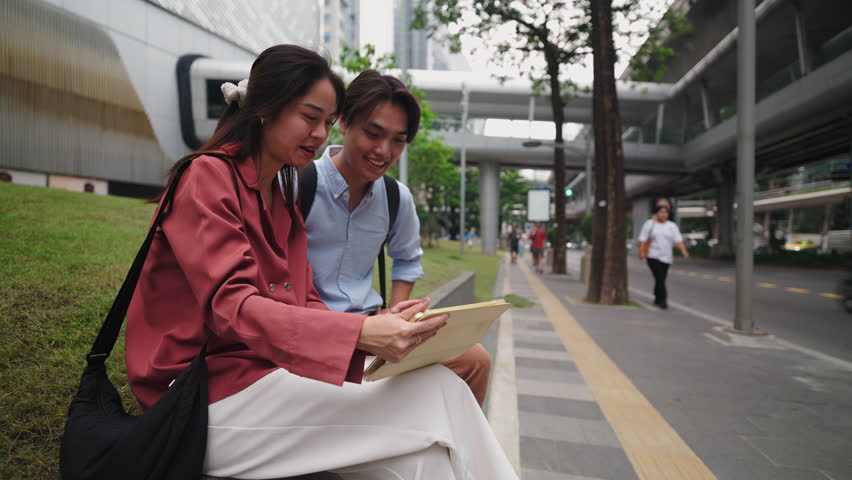 Business colleagues reviewing documents on a tablet in an urban setting