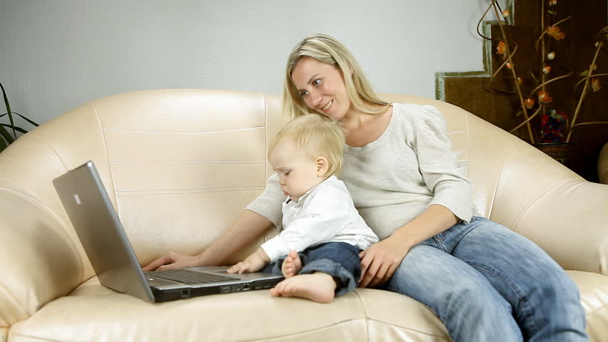 Mother with son on sofa watch laptop
