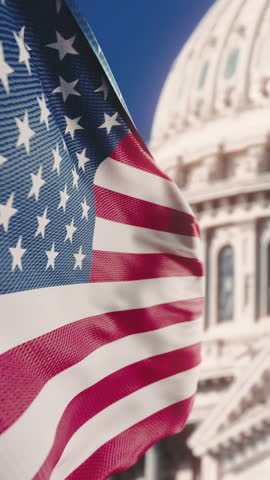 Wavy flag of United States of America waving in slow motion with the Capitol Rotunda Dome in Washington DC in the background. Official USA flag blowing in the wind