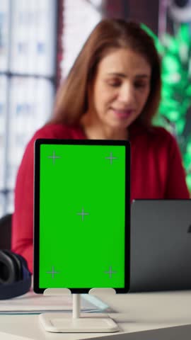 Vertical Video Woman organizing and planning activities on the agenda next to chroma key, overseeing time management for the schedule by using online tools as weekly planner and digital calendar