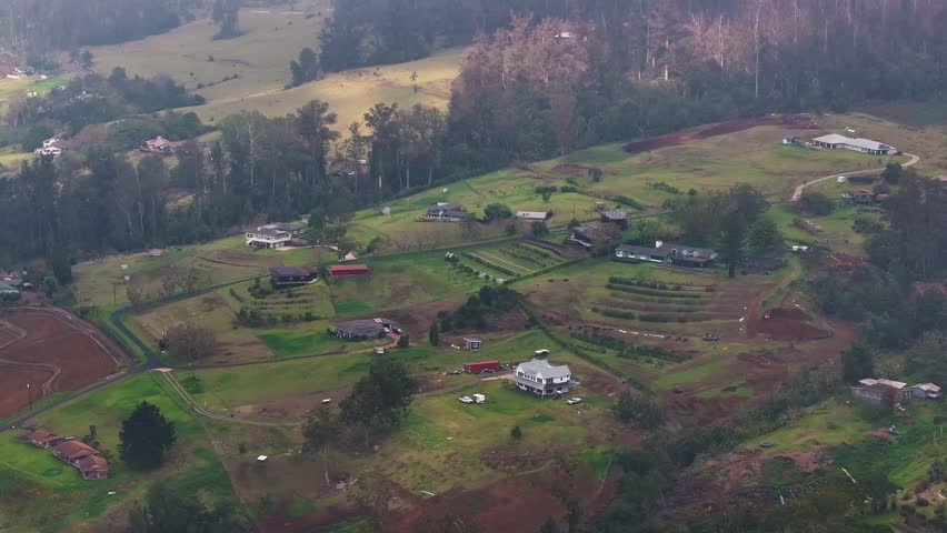 Aerial view of mountainside homes and farms in the countryside on Maui, Hawaii island lanscape - 4K Drone