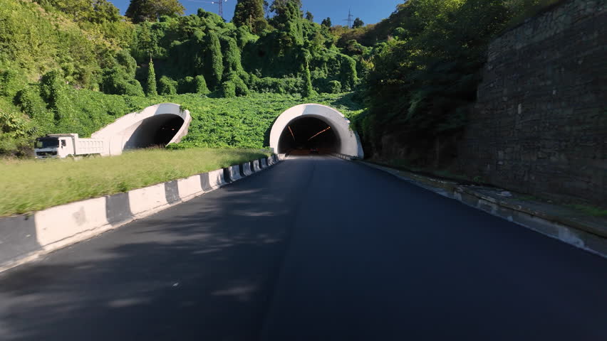 Driving inside car tunnel in mountain.