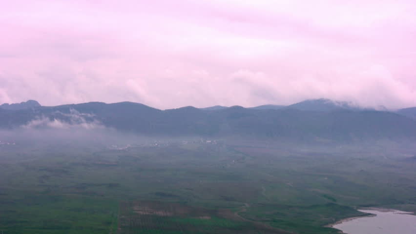 Panorama hilly terrain, almost hidden pink mist