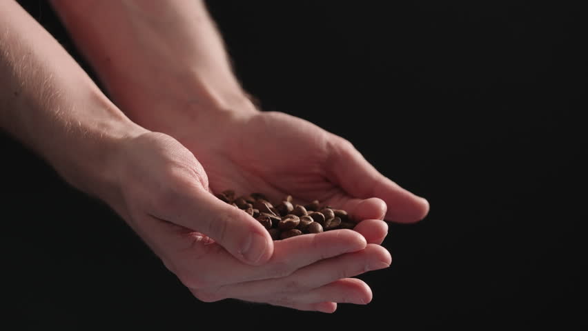 Slow motion mam pour coffee beans over balck background