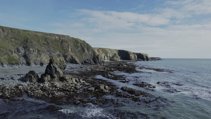 Ireland epic coastline drone flying slowly overdramatic rock formations and cliffs Copper Coast Waterford Ireland in spring