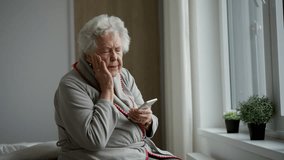 Horrified senior woman scrolling her smartphone. Phone scams on elderly people. - Powered by Shutterstock - Get 15% off with code: PIKWIZARD15