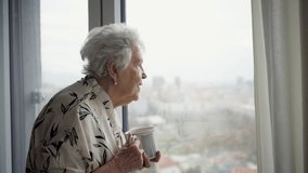 Beautiful old woman looking out of window, expecting a visitor. - Powered by Shutterstock - Get 15% off with code: PIKWIZARD15