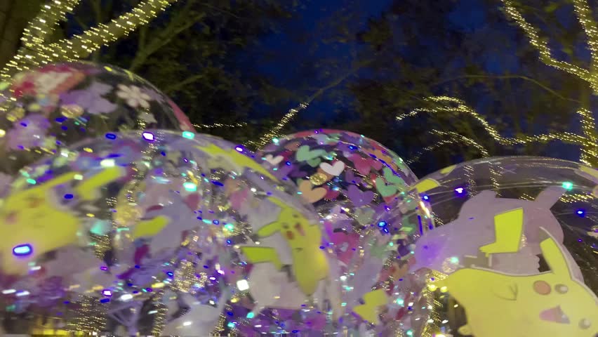 Festive night illumination hung on trees. In the center of the composition are two large balls of glowing lights. Majorca Island. Spain.